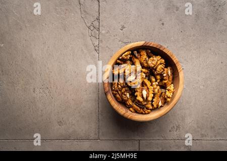 walnut nuts in a bowl on gray stone background top view with copy space. Healthy snack food. Stock Photo