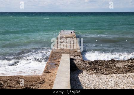 Seagulls and cormorants are on an old breakwater, summer landscape photo taken at the Black Sea coast on a sunny summer day, Crimea Stock Photo