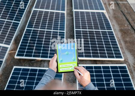 Engineer using solar system application. Checking solar panel setup.  Stock Photo