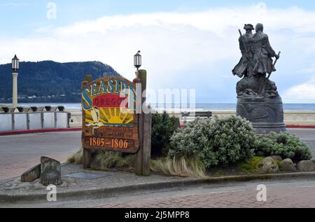 A sign on the waterfront for the coastal holiday town of Seaside, Oregon, USA with a statue of explorers Lewis and Clark at right. Stock Photo