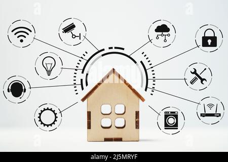 IOT or Internet of Things and smart home. Icons around the house model Stock Photo