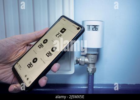 A smart radiator valve connecting to a smartphone app Stock Photo
