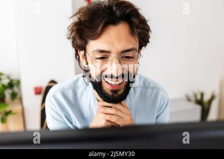 Successful freelancer smiling while having a video call on laptop at home Stock Photo