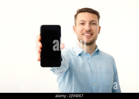 The man shows on the copyspace screen of the smartphone. Isolated on a white background. Stock Photo