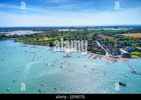 Itchenor Village and sailing destination over the Sailing Boats anchored in the estuary with beautiful reflections on the water, Aerial photo. Stock Photo
