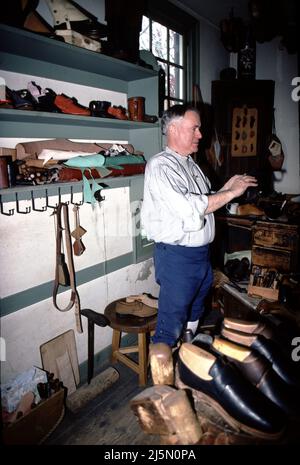 Williamsburg, CA. U.S.A. 9/1987. Cordwainer was the title given to shoemakers.  Cobblers were those who repaired shoes.  The cobbler had as much as five years less training than a cordwainer.  The American colonies, cobblers were prohibited by proclamation from making shoes.  The first shoemakers, tanners and other tradesmen arrived in Jamestown in 1607. among the colony’s principal founder John Smith’s many talents, was that of shoemaker –  the settlement was partially funded by a thriving English shoe trade. Stock Photo