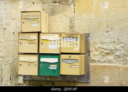 Old mail boxes without names on a yellow wall in France Stock Photo