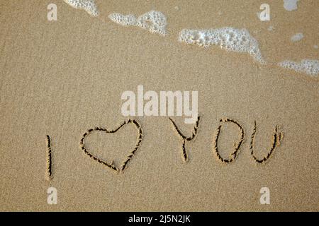 I love you - handwritten on the soft beach sand. Stock Photo