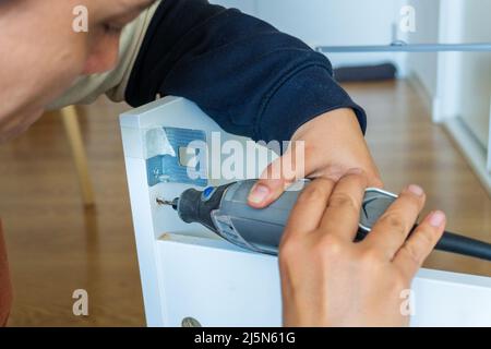woman using mini drill and doing bricolage Stock Photo
