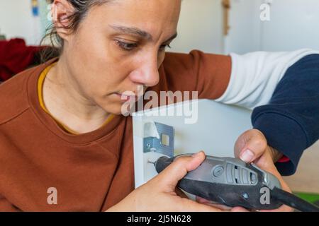 woman using mini drill and doing bricolage Stock Photo