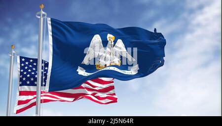 The Louisiana state flag waving along with the national flag of the United States of America. In the background there is a clear sky. Louisiana is a s Stock Photo