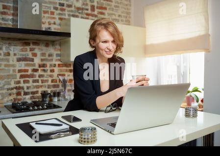 A woman on an online briefing discusses business with her colleagues at home. Stock Photo