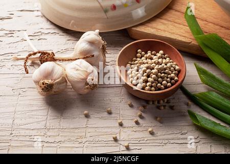 kitchen spices consisting of garlic, pepper and scallions on the table Stock Photo