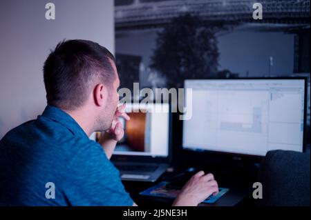 Mature man sitting at the table using computer for business Stock Photo