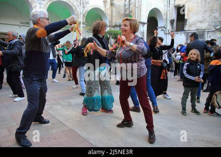 April 24, 2022, Pagani, Campania/Salerno, Italy: Men and women, young and old, seen for the old town dance the ''Tammurriata'' on the day of the feast of Santa Maria Incoronata del Carmine called ''Madonna delle Galline''. The most important feature that surrounds the entire festival is the tammurriata, a frenzied popular music that breaks out on Friday in albis, accompanies the population for the entire day of Sunday and ends at dawn on the following Monday, when the people of the devotees go to lay at the feet of Our Lady the tammorras used during the feast. The tammorra is a frame drum th Stock Photo