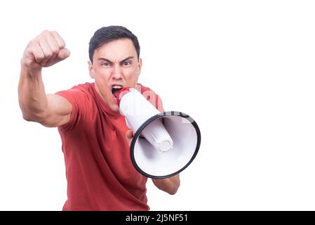 Guy screaming in megaphone and raising fist in studio Stock Photo