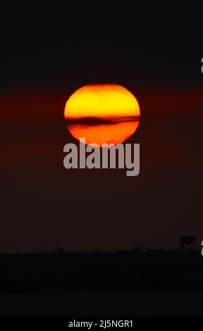 25/04/2022 East Tilbury UK The sun climbing through thick mist and a Low cloud base over East Tilbury. The overcast conditions allowing viewing of a l Stock Photo