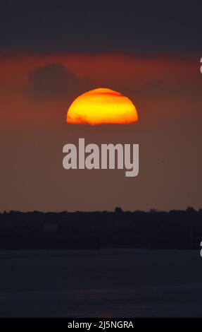 25/04/2022 East Tilbury UK The sun climbing through thick mist and a Low cloud base over East Tilbury. The overcast conditions allowing viewing of a l Stock Photo