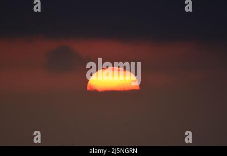 25/04/2022 East Tilbury UK The sun climbing through thick mist and a Low cloud base over East Tilbury. The overcast conditions allowing viewing of a l Stock Photo
