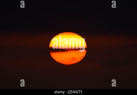 25/04/2022 East Tilbury UK The sun climbing through thick mist and a Low cloud base over East Tilbury. The overcast conditions allowing viewing of a l Stock Photo