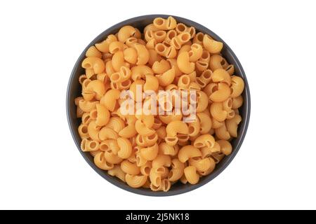 Dry uncooked pasta in a black ceramic cup isolated on a white background. View from above Stock Photo