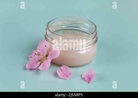 Natural organic eco cosmetics. SPA beauty salon branding mockup. Cosmetic containers with cream  and spring flowers  on a green background. Stock Photo