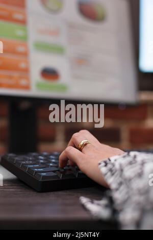 Close up of financial agency office worker on computer, developing marketing strategy while using keyboard. Advertising company businesswoman working on business project and department management. Stock Photo