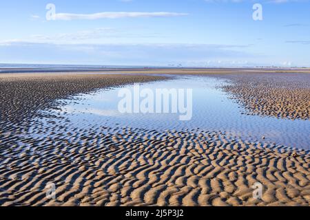 Low tide calm conditions and a sunny April morning at Dymchurch beach on the coast of Kent south east England UK Stock Photo
