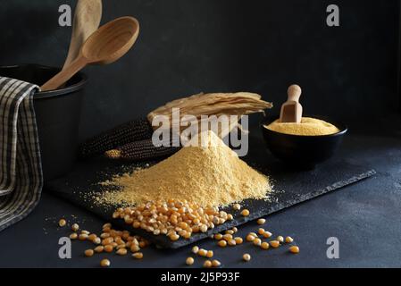 Cornmeal and corn kernels on a black background. Stock Photo