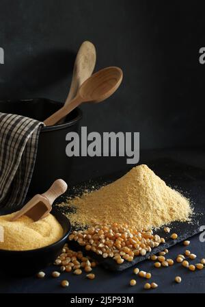 Cornmeal and corn kernels on a black background. Stock Photo