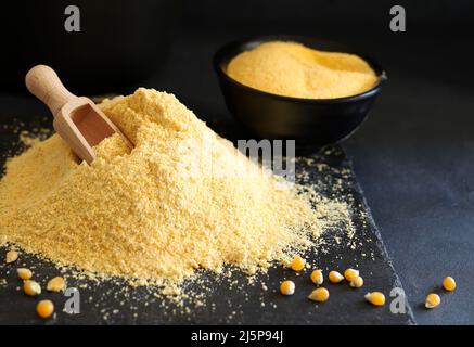 Cornmeal and corn kernels on a black background. Stock Photo