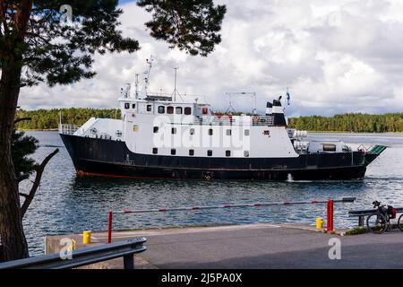 Small ferry carrying passengers and vehicles arriving in the harbor. Turku Archipelago, Finland Stock Photo