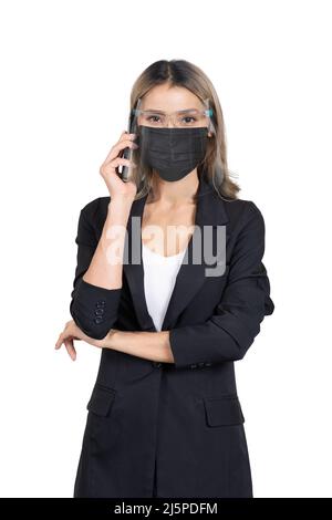 New normal business woman wearing mask and face shield using smartphone on white background. Stock Photo