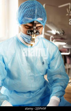 Dentist in binoculars, use of binoculars in dental treatment, dentist in the office, magnifying glass for binoculars. Stock Photo