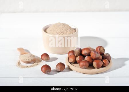 gluten free low carb flour made of ground hazelnuts. ketogenic diet ingredient for baking at home. hazelnuts and flour in a spoon Stock Photo