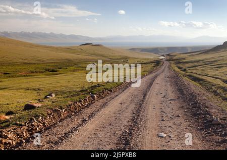 Unpaved road and yurts near Son-Kul lake and Tien shan mountains in Kyrgyzstan Stock Photo