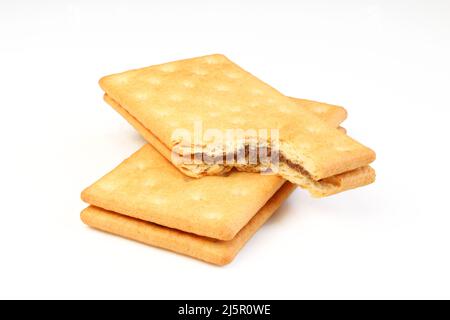 Bitten sandwich cookie filled with chocolate on top of whole one isolated on white background Stock Photo