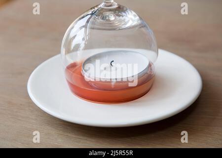 https://l450v.alamy.com/450v/2j5r55r/lemonade-on-a-saucer-is-sucked-into-a-glass-that-is-placed-over-a-burning-candle-because-the-flame-is-using-the-oxygen-it-causes-a-kind-of-vacuum-in-2j5r55r.jpg