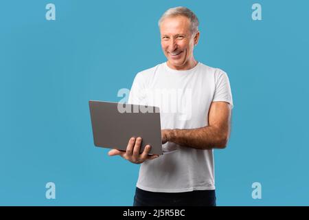 Confident mature man holding and using laptop Stock Photo