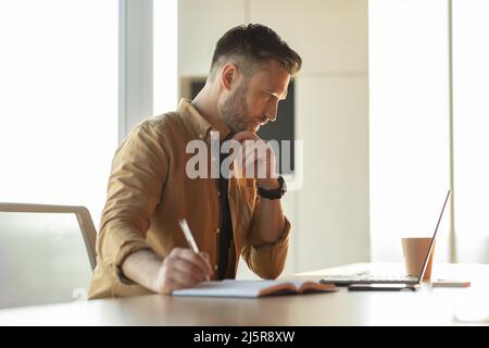 Businessman Writing Taking Notes Making Business Report Sitting In Office Stock Photo