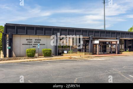 MOORESVILLE, NC, USA-17 APRIL 2022: Front view of Mooresville U.S. Post Office, with identifying sign and entrance.  Bllue sky, sunny, spring day. Stock Photo