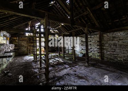 Old store room in abandoned slate quarry with metal racks, disused slate quarry, landscape Stock Photo