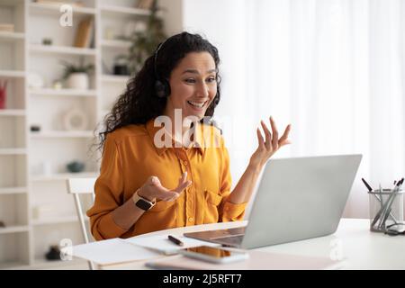 Cheerful Lady Talking Wearing Headset Making Video Call In Office Stock Photo
