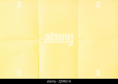 Light Yellow crumpled unfolded paper sheet texture background. Paper folded in six. Full frame Stock Photo