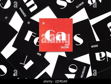 Cards with the names of the chemical elements of the periodic system. Alfabet of electrolytes on red cardboard. Top view Stock Photo