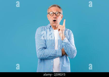 Excited mature man has great idea and pointing finger up Stock Photo