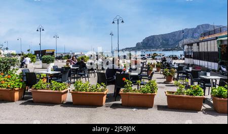 People eating out in a restaurant near the seafront in the village of Mondello, Sicily, Italy. Stock Photo