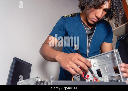 young brunette male technician working on desktop computer maintenance, focus on hands, copy space Stock Photo