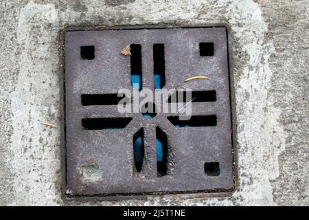 A small hatch for receiving rainwater or melted snow. Against the background of gray granite paving slabs. View from above Stock Photo