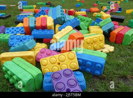 Multi colored plastic building blocks for children to play with on grass Stock Photo